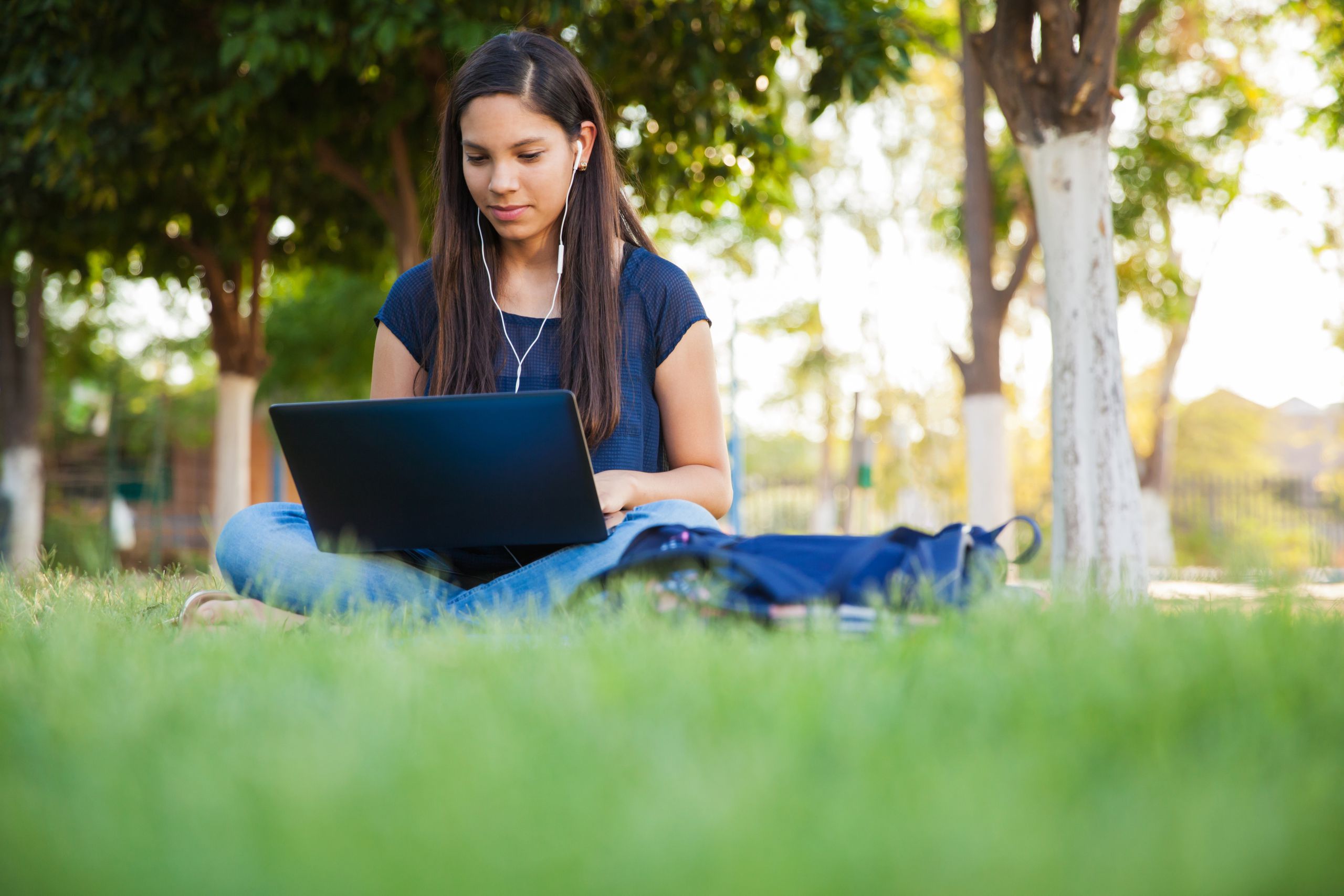 Teen girl using laptop outside